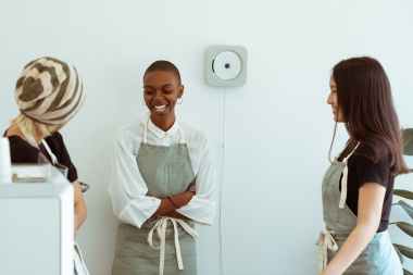 happy diverse baristas chatting happily during break at work